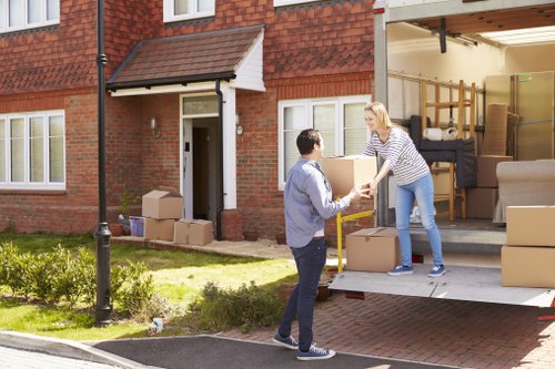Moving boxes and furniture being loaded by Haringey movers in a residential street