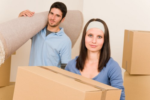 Professional movers carrying household items down stairs in a Haringey flat